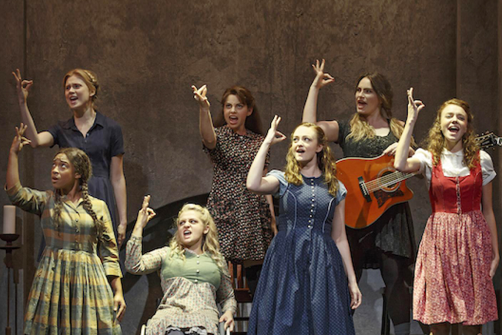 데프 웨스트 시어터의 <스프링 어웨이크닝>의 한 장면. 7명의 여성 배우가 같은 손동작을 하며 노래를 부르고 있다.