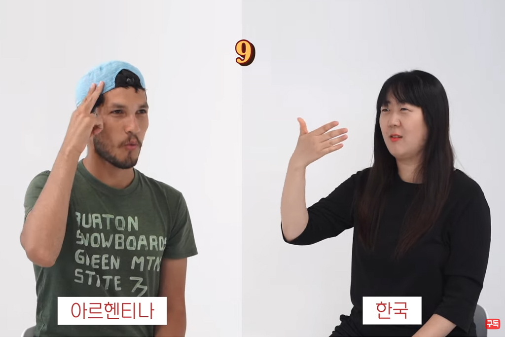 하개월 유튜브 영상 캡처. 화면 왼쪽에는 아르헨티나 남성, 오른쪽에는 한국 여성 하개월이 있다. 둘은 각 국가의 수어로 숫자 9를 표현하고 있다.