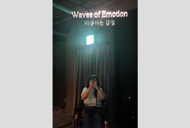 거울에 ‘waves of emotion 파동하는 감정’이라는 문구가 새겨져 있고, 그 안에 셀카를 찍는 서주현 님이 보인다.