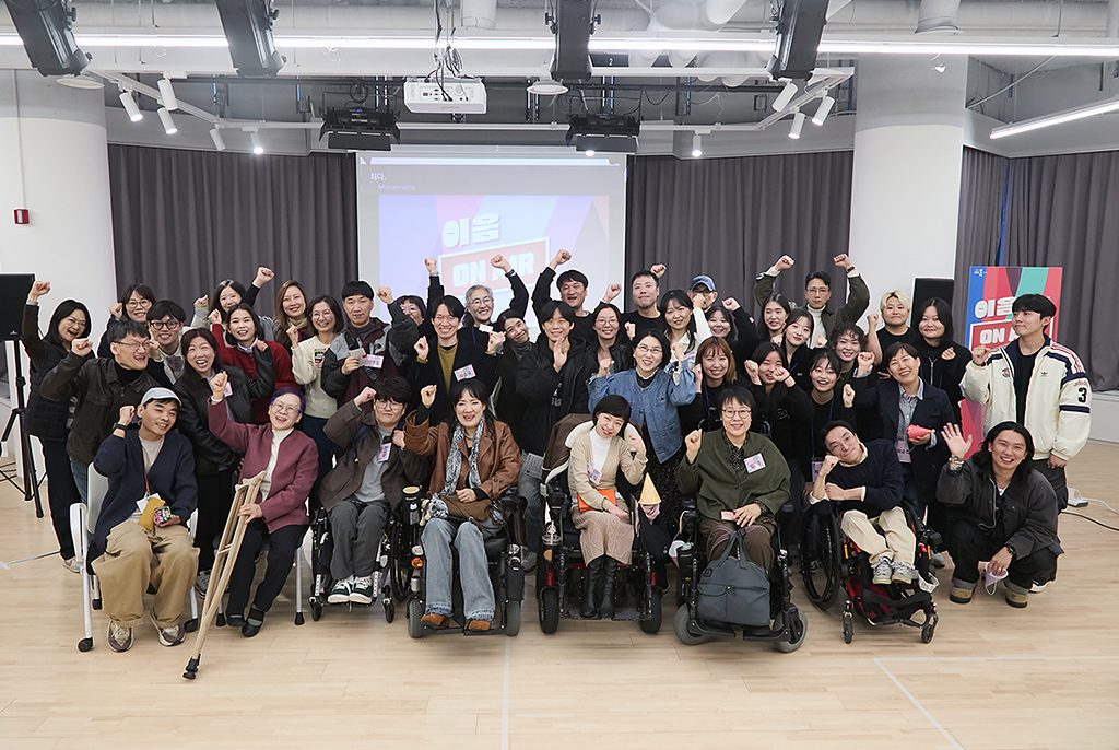 2부 네트워킹 후 모두 모여 단체 기념사진을 찍었다. 손을 번쩍 들거나 손가락 하트를 날리는 등 다양한 포즈와 환한 표정으로 카메라를 바라보고 있다.